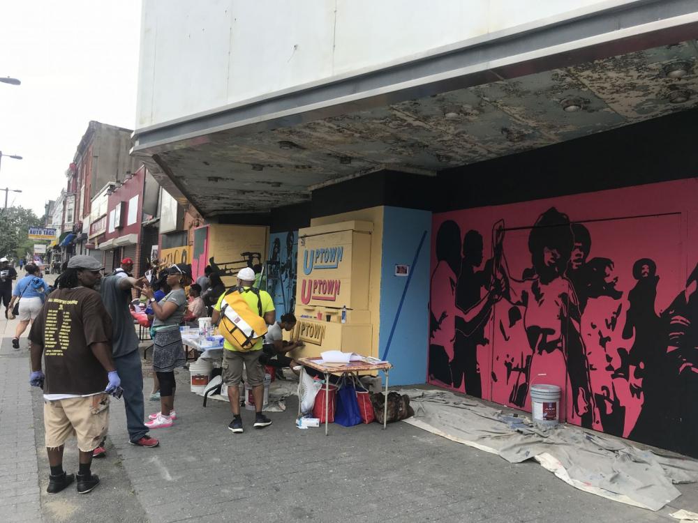 community members painting a mural at the Uptown Theater